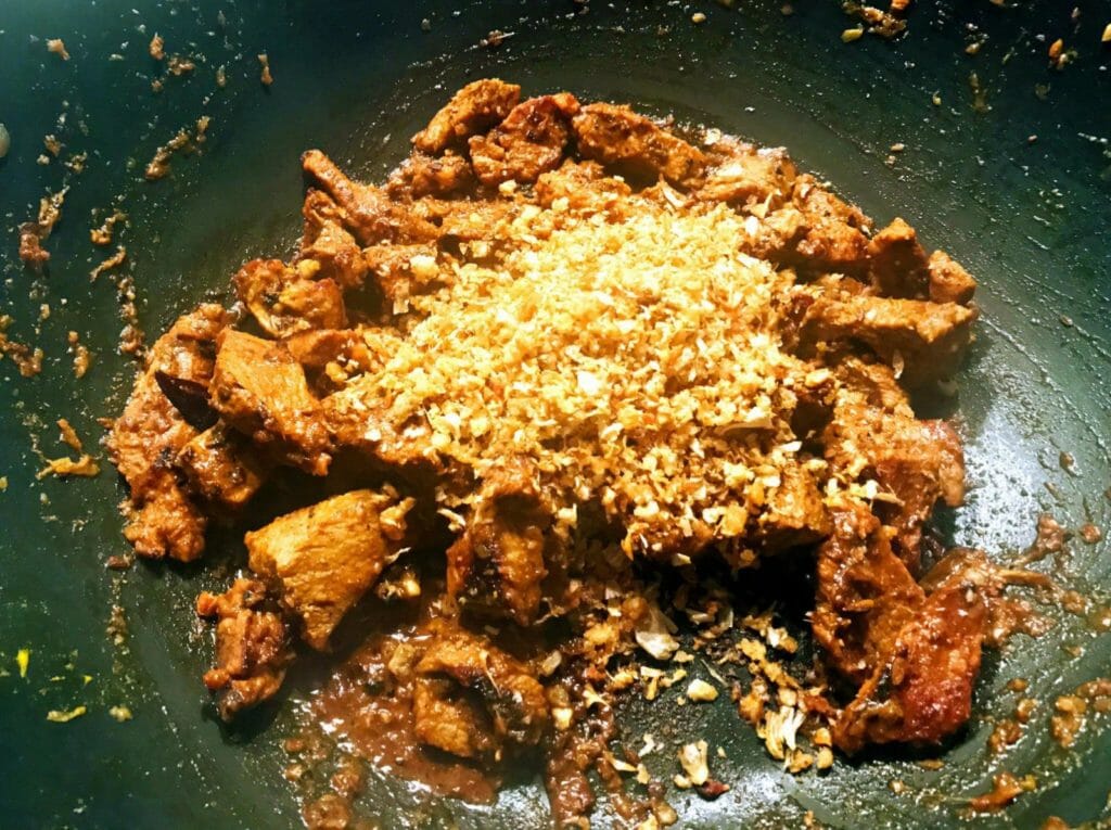 Add ground spices to lamb bhuna