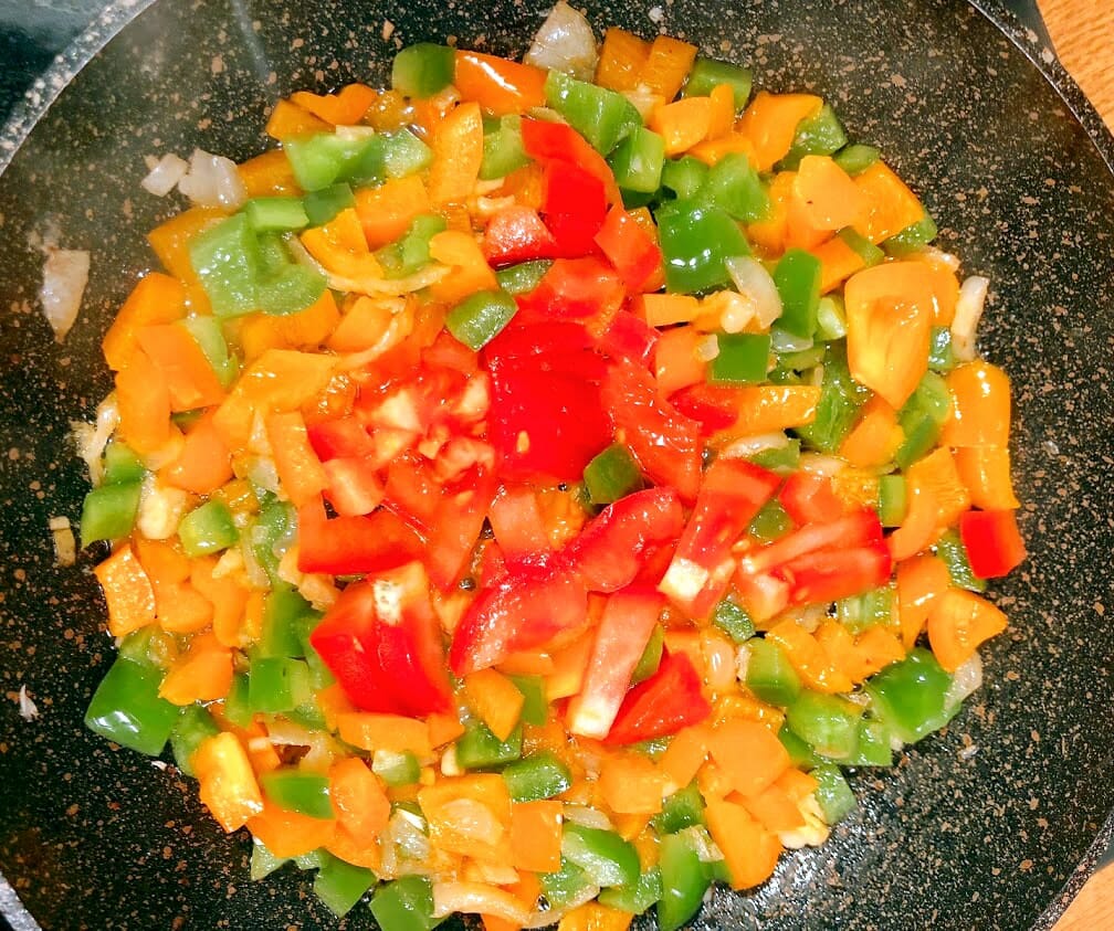 Add toamtoes to sauteed peppers